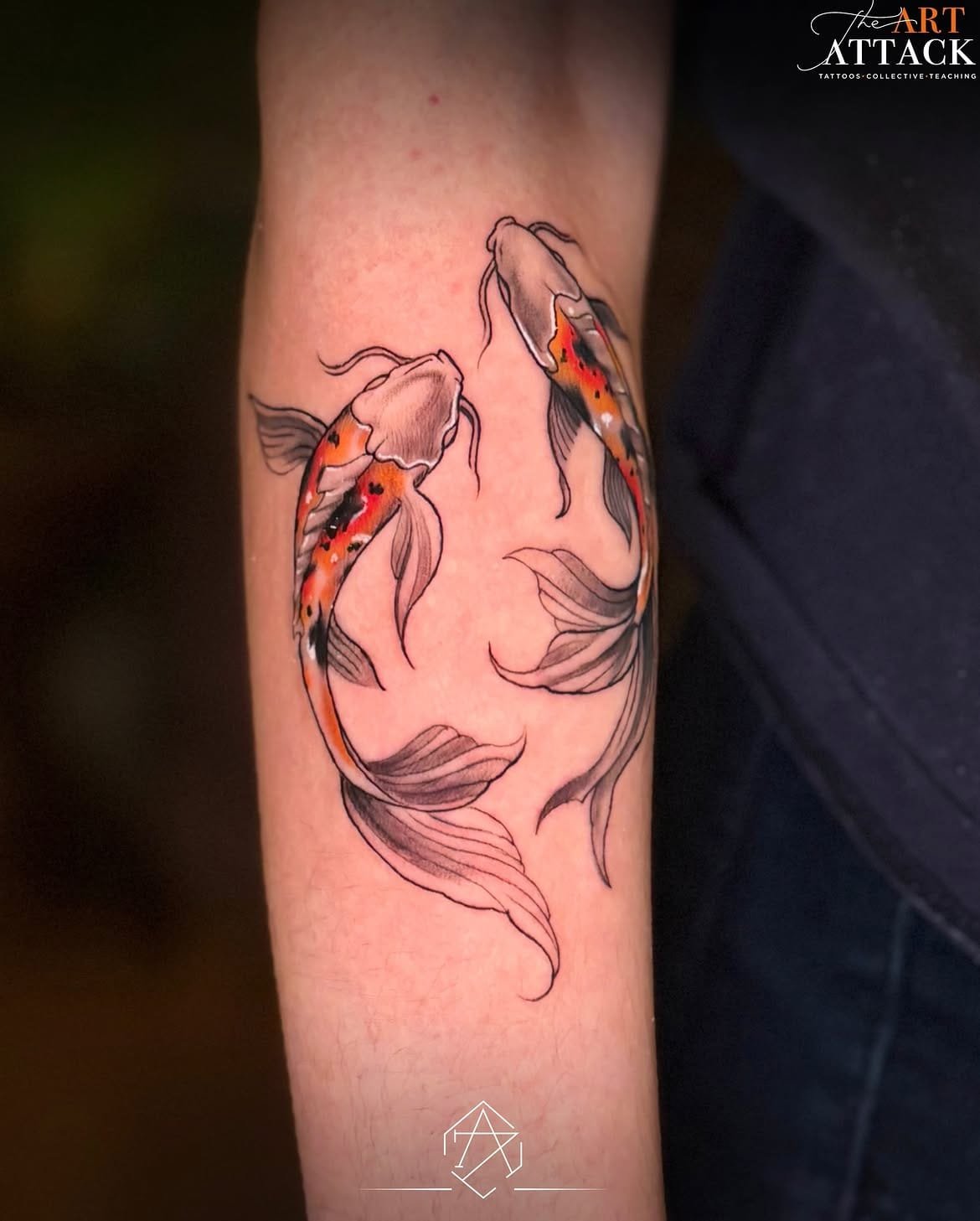 Two koi fish tattooed along a forearm in orange and black ink.