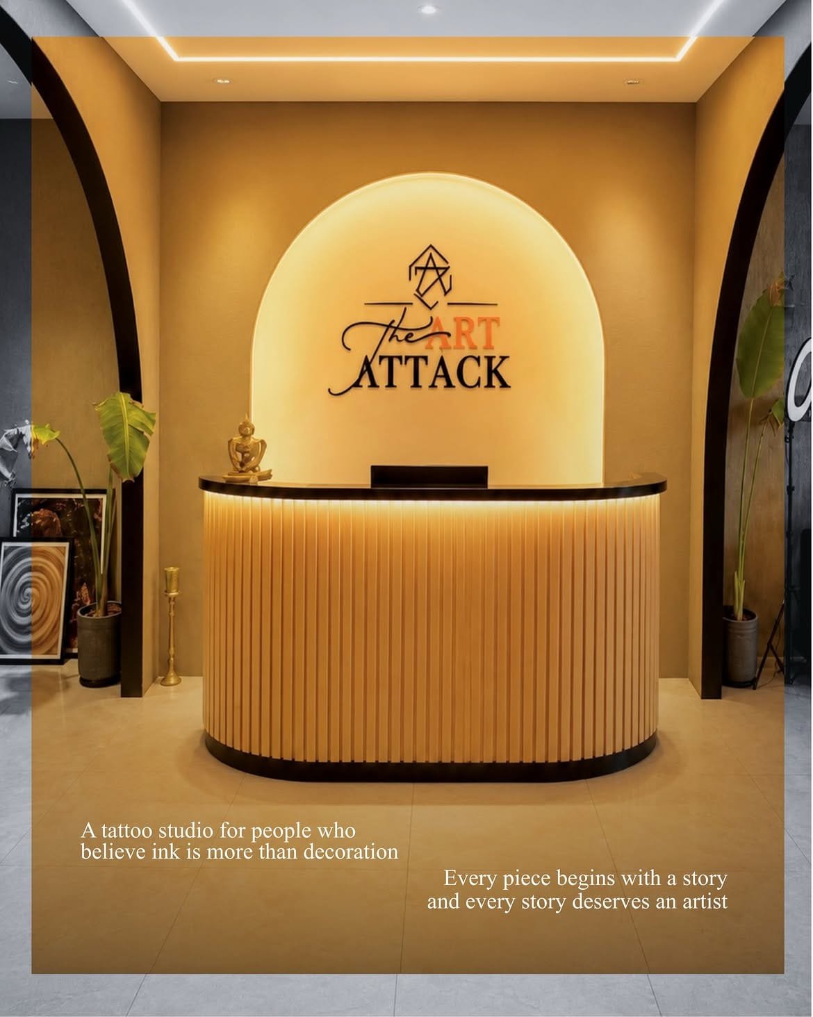 The reception desk at The Art Attack, lit beneath an arch carrying the studio logo.