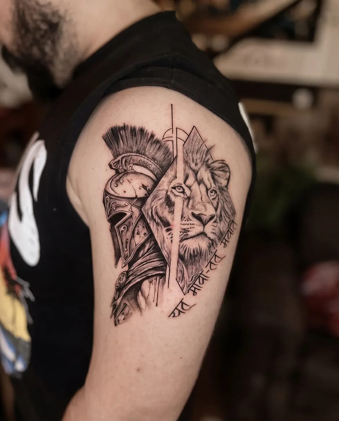 Black and grey upper-arm tattoo of a helmeted warrior beside a lion.